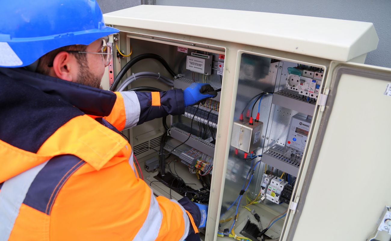 An electrical contractor inspecting and working at an electrical panel